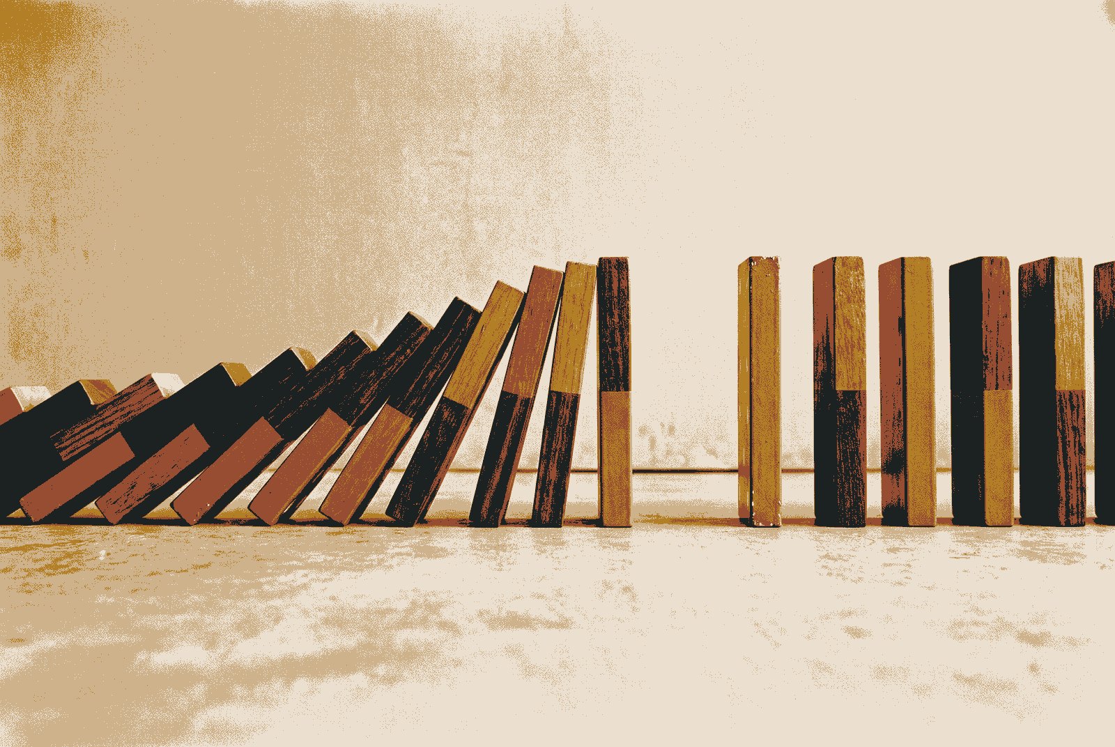 A long line of tall dominoes seen side-on, toppling in sequence, stopped just short of a noticeably wider gap between two of them.