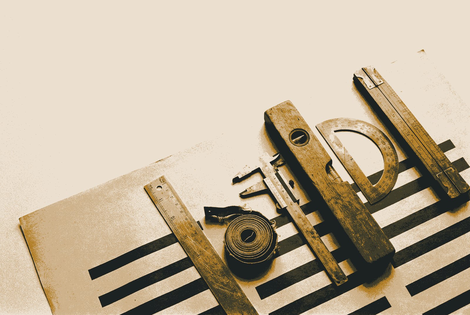 Six worn measuring tools, a steel rule, a coiled tape, calipers, a wooden spirit level, a protractor and a folding rule, laid in a diagonal row across a sheet printed with thick horizontal bars.