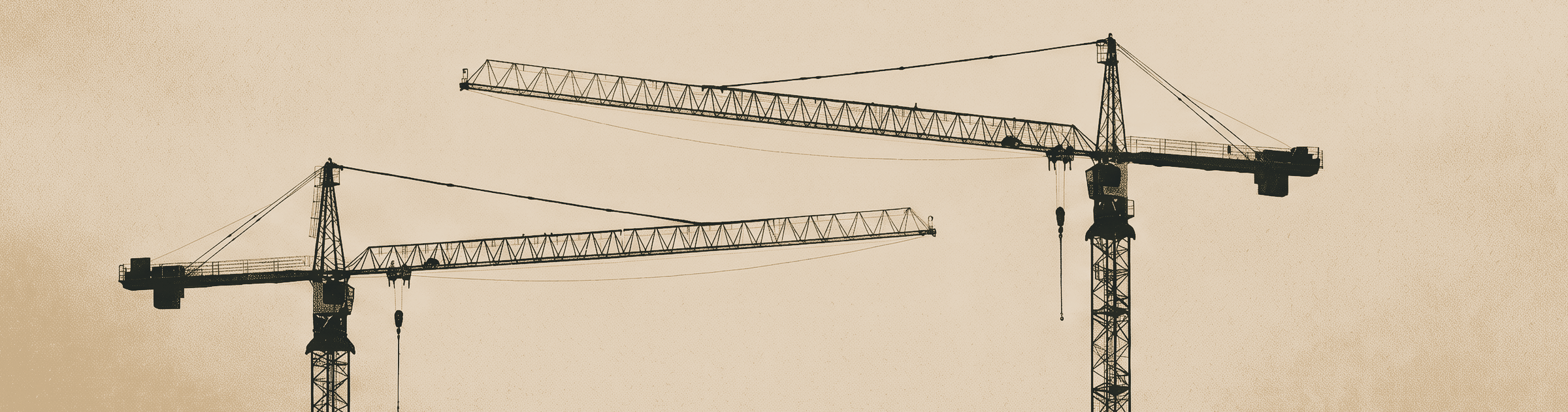 Two tower cranes standing idle against a pale sky, their jibs crossing.