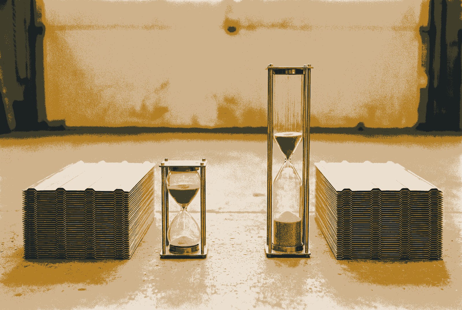 Two identical stacks of cladding panels side by side, one beside a short hourglass and the other beside a much taller one.