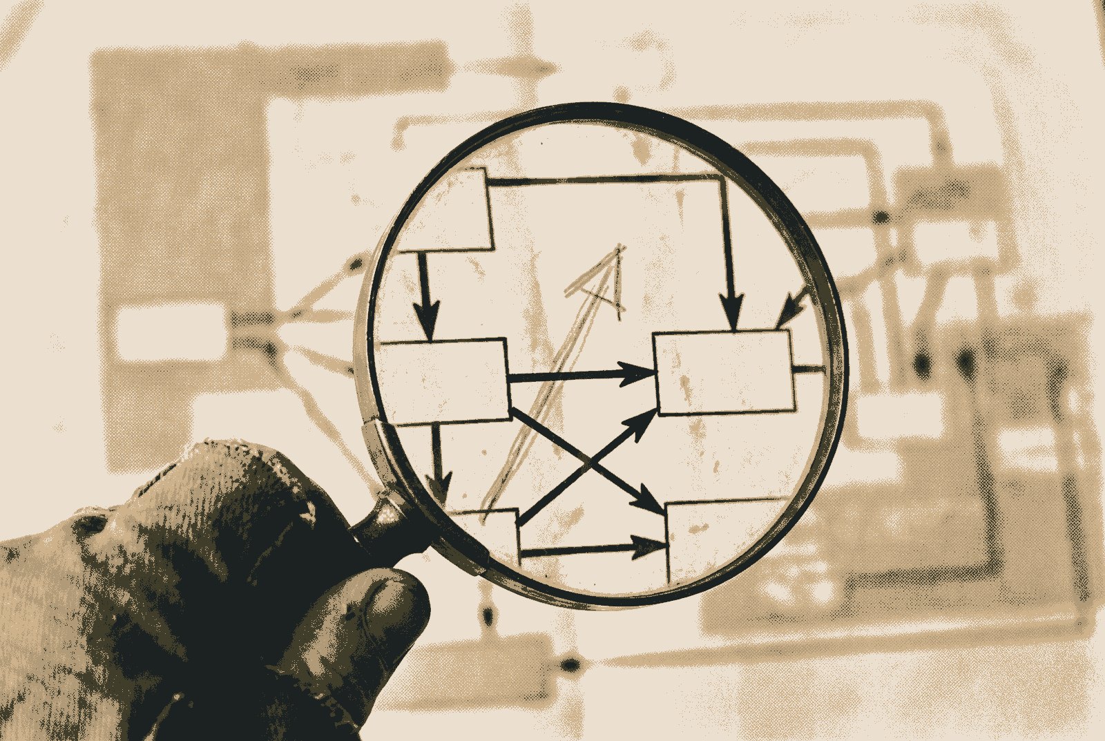 A magnifying glass held over a printed network diagram of boxes and arrows; inside the lens one arrow has been redrawn in pencil at a different angle.